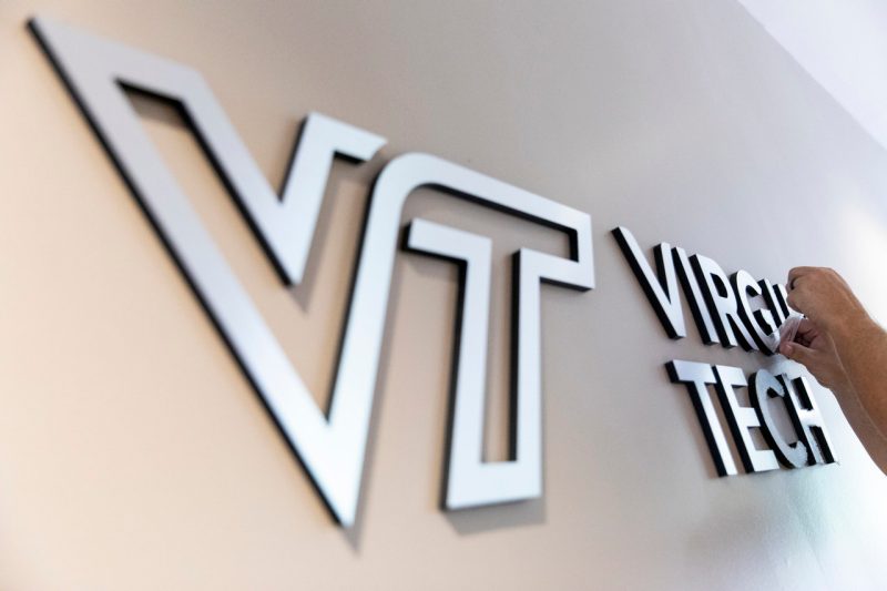 Virginia Tech logo being installed on a wall